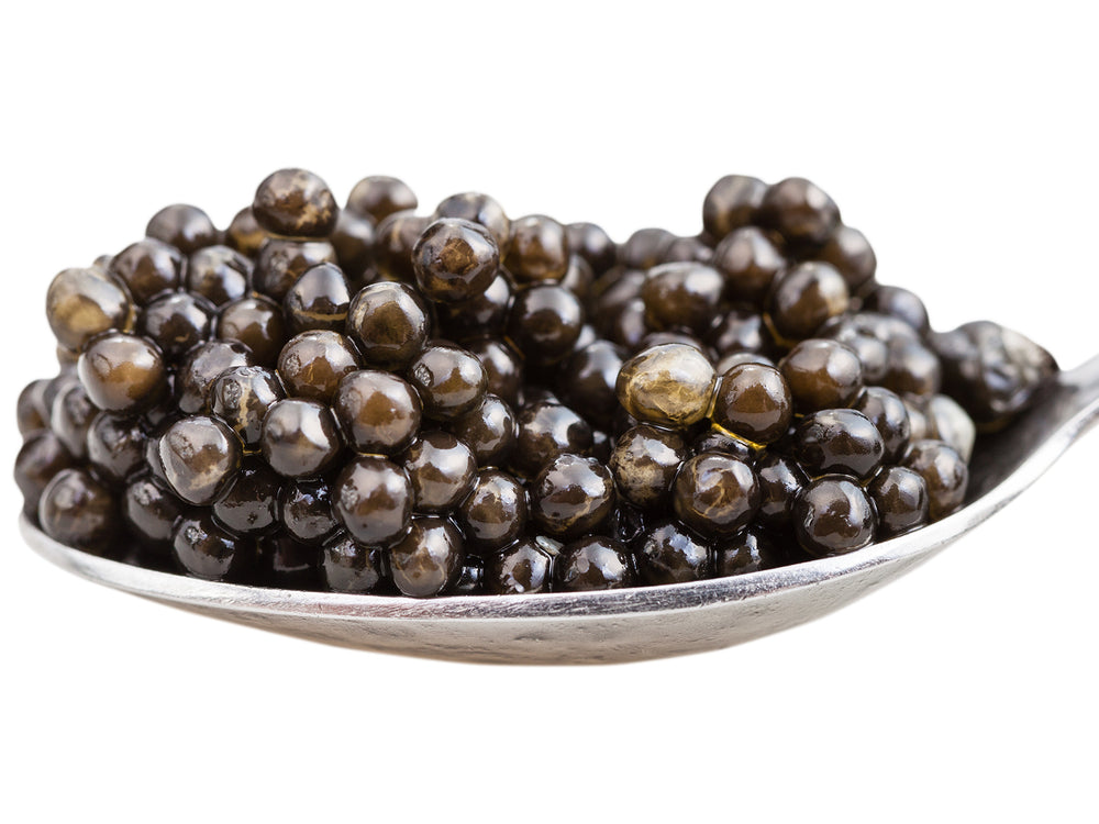 A silver caviar spoon filled with the black gelatinous balls.